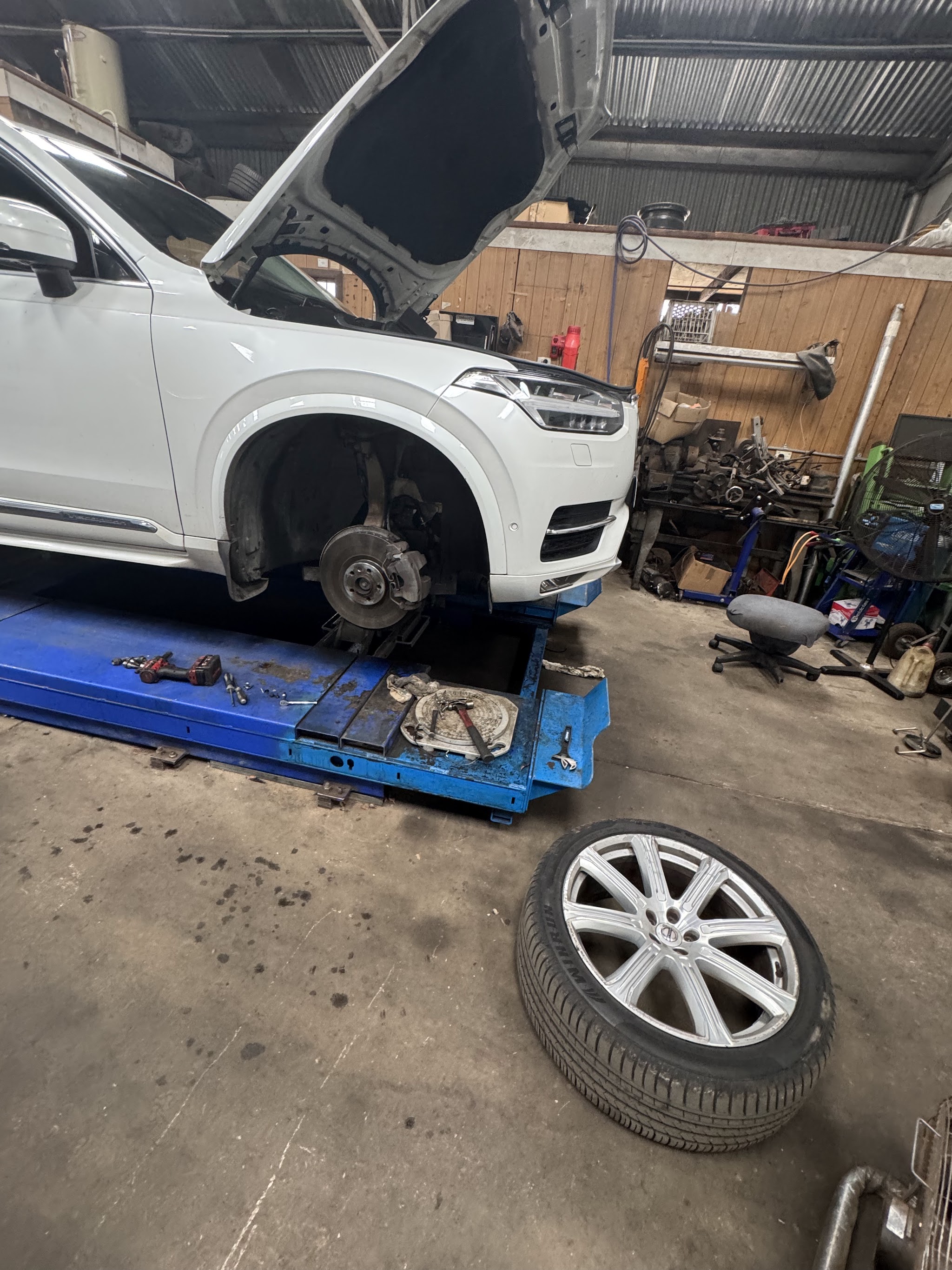 Inside the KO AUTO workshop in Bellingen, a car up on the hoist with a wheel off
